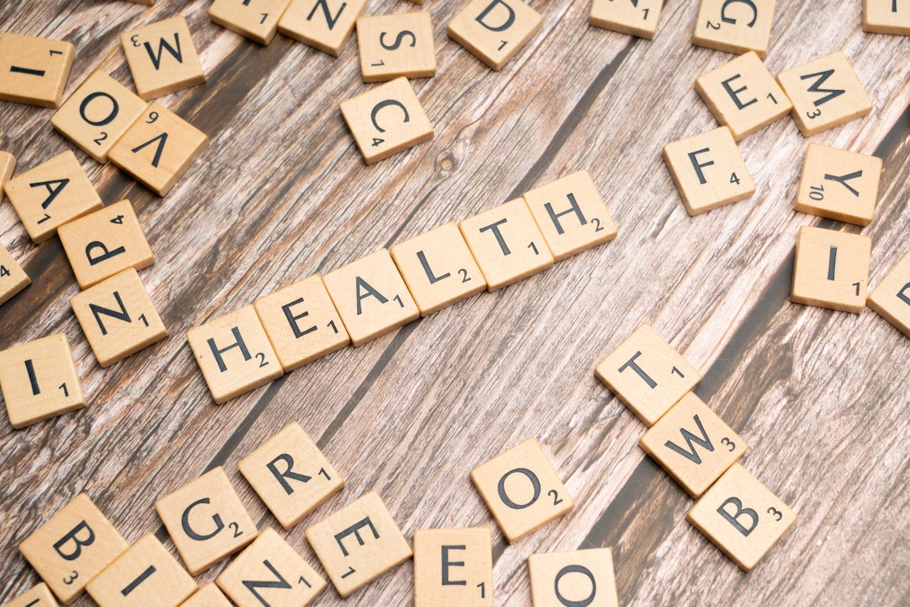 Home Scrabble tiles spelling 'HEALTH' on wooden surface, symbolizing wellness.