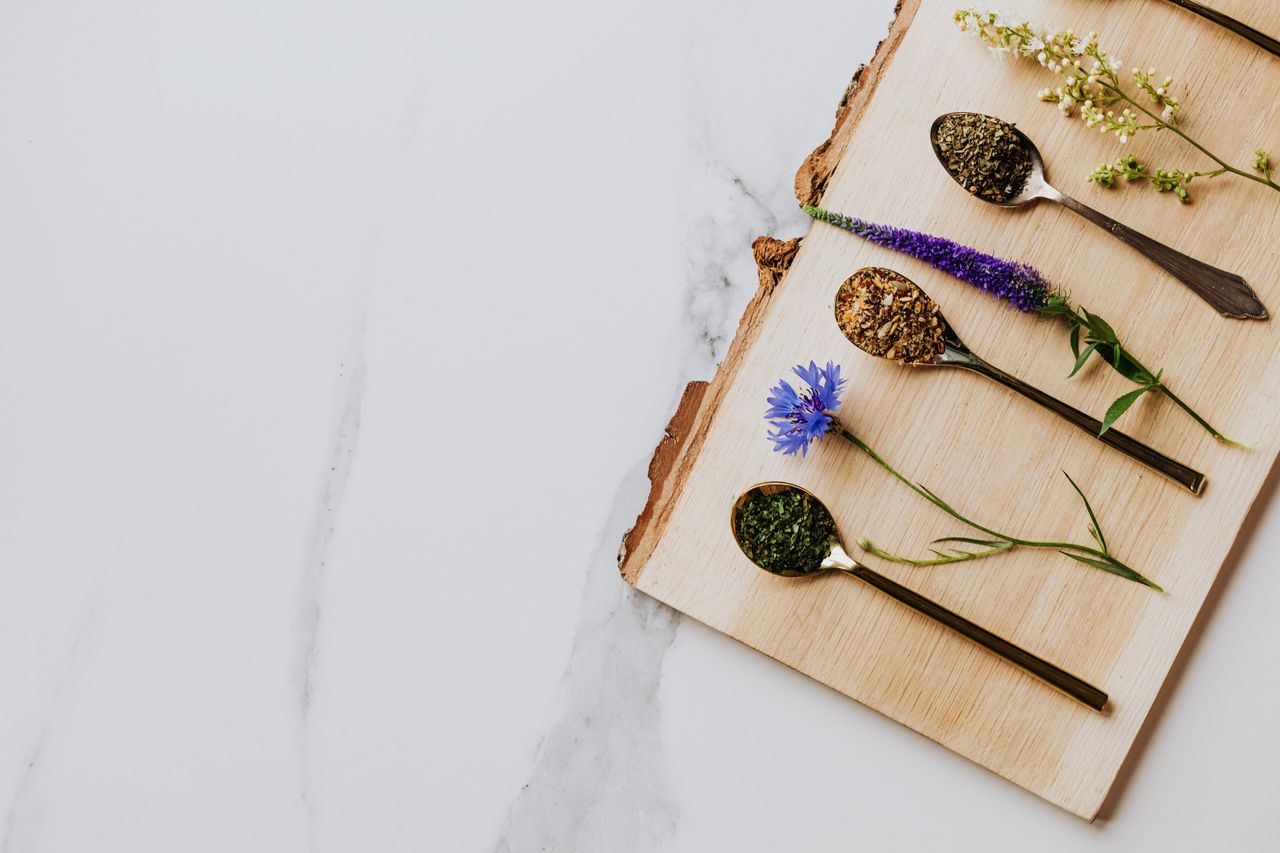 Home A beautiful flat lay of herbal teas and flowers on a wooden board. Perfect for culinary or wellness themes.