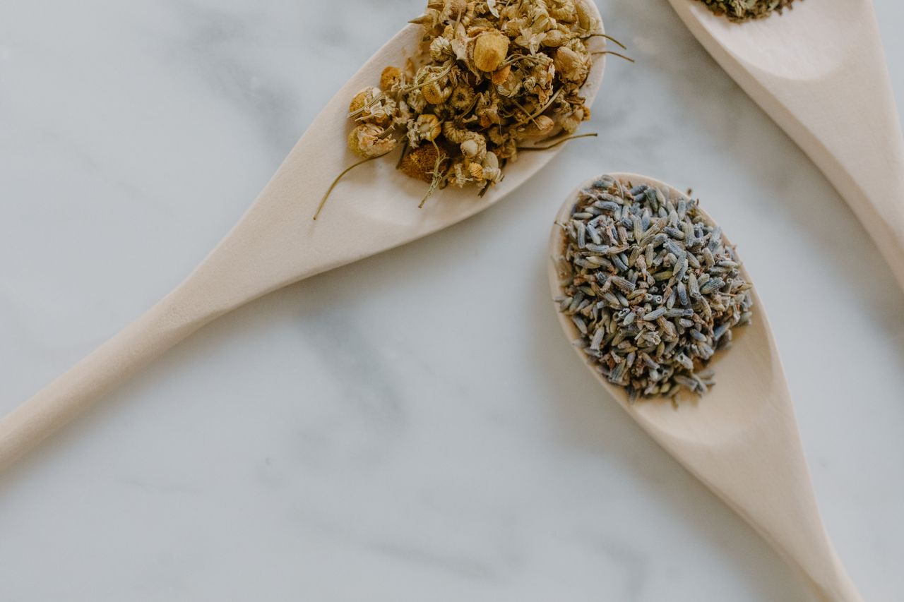Crafting Captivating Headlines: Your awesome post title goes here Close-up of chamomile and lavender dried herbs in wooden spoons on white marble.